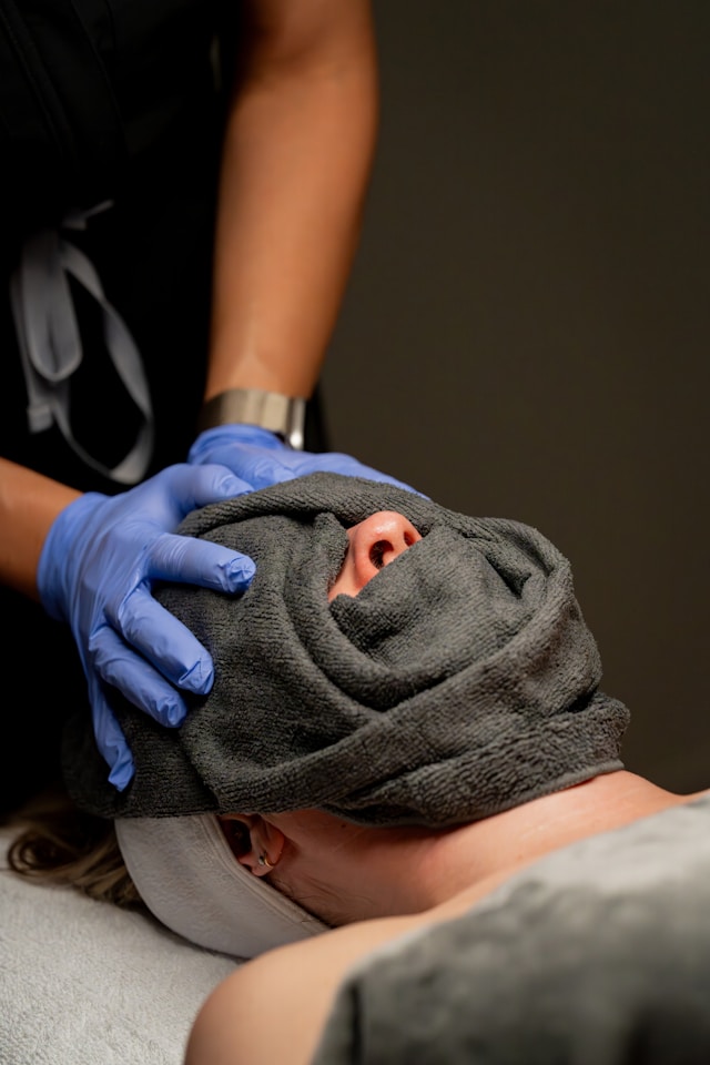Trattamento spa per viso con panno caldo durante il percorso cute